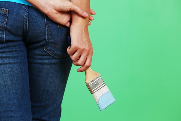 woman paints the wall brush
