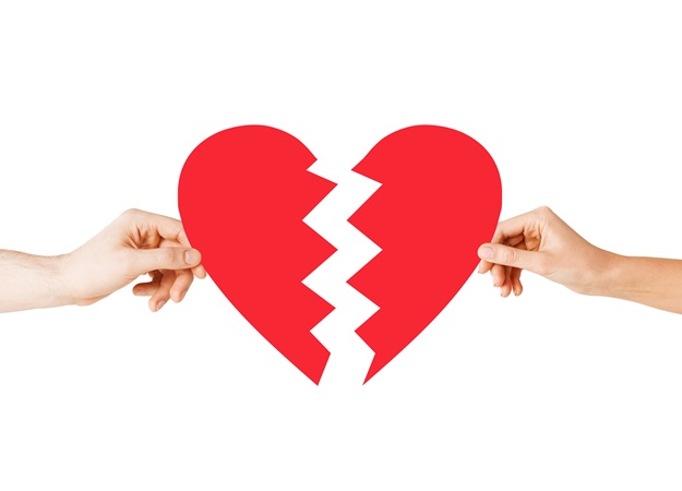love and relationship problems concept - male and female hands holding two parts of broken heart